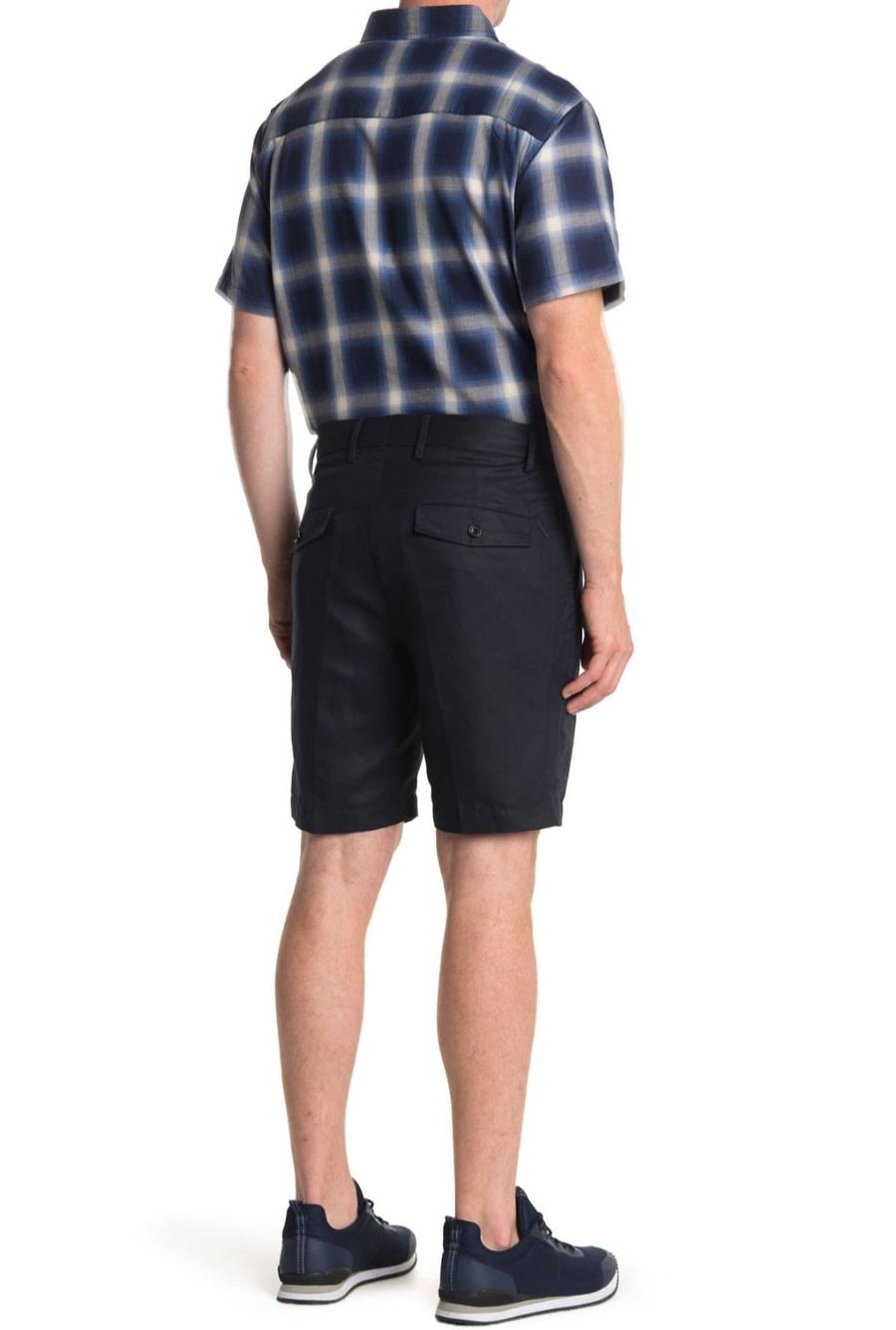 Back view of Joe Cummings modeling a plaid shirt and shorts, e-commerce fit photo
